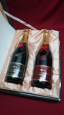 two bottles of champagne in a gift box on a table