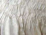 a close up of a bed with a white bedspread and a black headboard