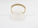 une bague en or jaune sertie de cinq diamants sur fond blanc