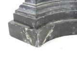 a statue of a man sitting on top of a marble block