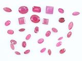 un gros plan sur un bouquet de pierres précieuses roses posées sur une surface blanche