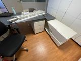 a desk with a computer and a chair in a room