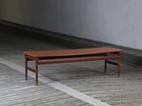 a wooden bench sitting on a wooden floor in an empty room
