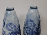 pair of blue and white vases sitting on top of a white table