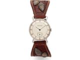 a close up of a wrist watch on a white surface