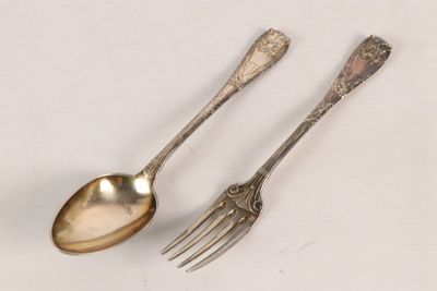 two spoons and a fork on a white surface