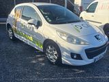 deux voitures garées sur un parking à côté d'une camionnette blanche