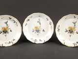 trois assiettes à motifs floraux posées sur une table