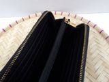 a close up of a purse on a wicker basket