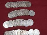 Plusieurs pièces d'argent sont disposées en rangée sur une surface rouge
