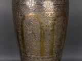 an antique brass vase on a grey background with a black background