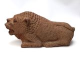 a small figurine of a lion on a white surface