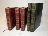trois vieux livres sont alignés sur une surface blanche