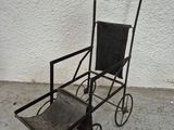 a small metal cart with a black seat on it