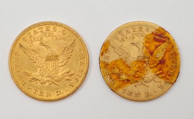 gros plan de deux pièces d'or sur une surface blanche
