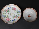 pair of porcelain bowls and saucers with floral designs on them