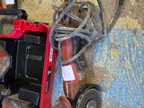 a red tool box with a drill and a corded cord in it