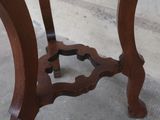 a wooden table with a glass top on a cement floor