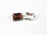 deux cristaux marron et blancs posés sur une surface blanche