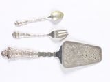 three silver spoons and a fork on a white surface