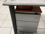 un bureau sur lequel se trouve un classeur, au milieu d'une pièce