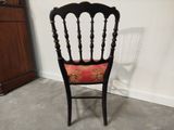 an image of a wooden chair with a red cushion on it