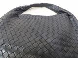 an image of a black woven bag on a white surface