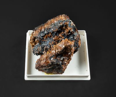 une assiette blanche sur laquelle repose un morceau de viande, posée sur une table noire