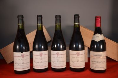 six bottles of wine are lined up on a red table