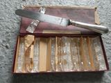 a knife in a box with a lot of empty wine glasses