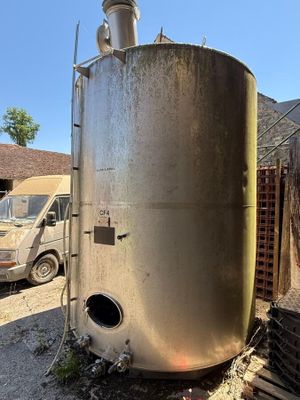 un grand réservoir métallique posé au milieu d'une cour