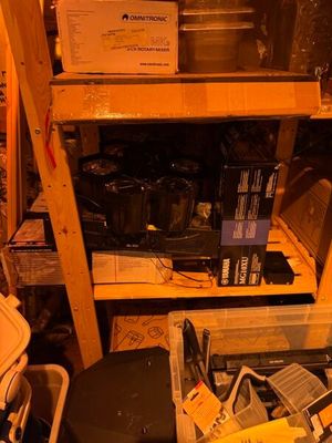 un tas d'appareils électroniques posés sur une étagère dans une pièce