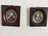 deux portraits encadrés représentant un homme et une femme, accrochés au mur