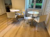 une table et des chaises blanches dans une pièce dotée d'une fenêtre