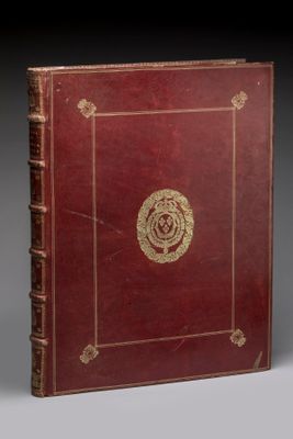 un vieux livre rouge avec un emblème doré sur la couverture