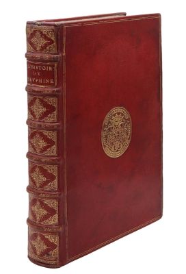 un vieux livre rouge orné d'un médaillon doré sur la couverture