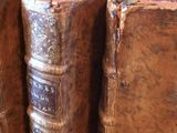 several old books are stacked on top of each other on a table