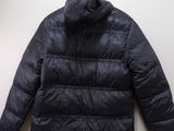 the back of a black puffer jacket hanging on a wall