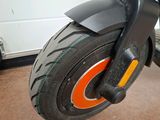a black scooter with orange wheels in a garage