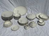 a lot of white dishes and cups on a table