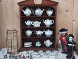 une étagère sur laquelle sont disposées de nombreuses théières de styles variés