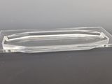a clear glass tray with a curved edge on a table