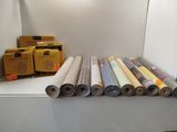 many rolls of paper sitting on a shelf next to a box