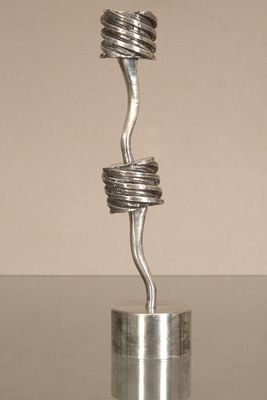 a metal sculpture of a spiral design on top of a glass table