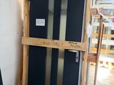 un réfrigérateur noir posé à côté d'une palette en bois dans une pièce
