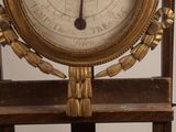 a clock that is on a stand with a clock on it