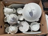 a cardboard box full of white and gold china