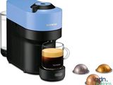 gros plan d'une tasse de café à côté d'une cafetière