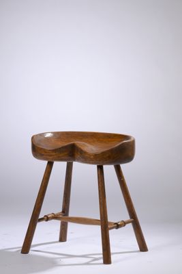 une photo d'un tabouret en bois posé sur un sol blanc