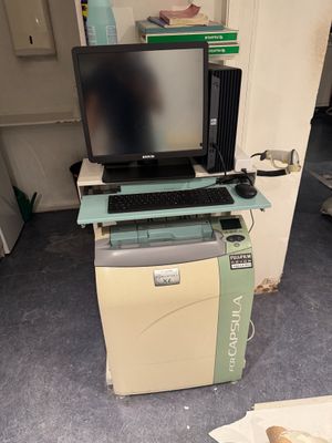 a computer sitting on top of a printer in a room
